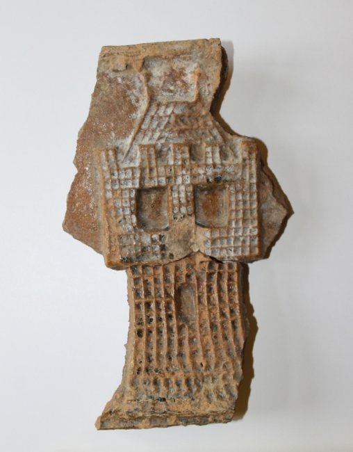 Fragment szkliwionych kafli z wieżyczką znaną z herbu Kościana.