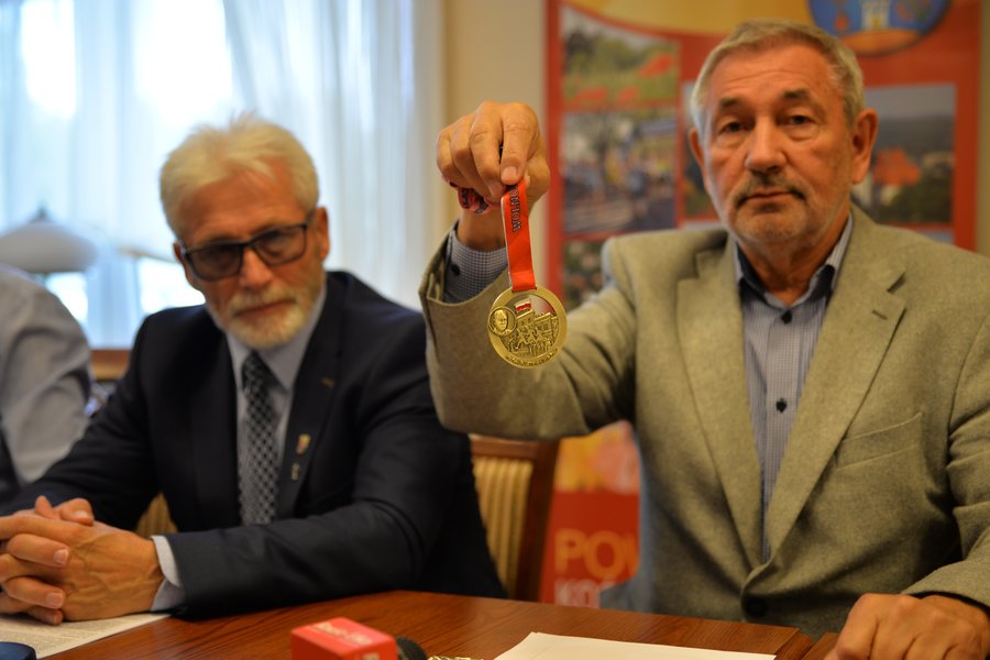 Edward Strzymiński prezentuje  medal tegorocznego półmaratonu